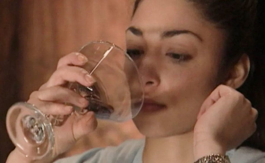 A contestant drinks from a champagne glass.
