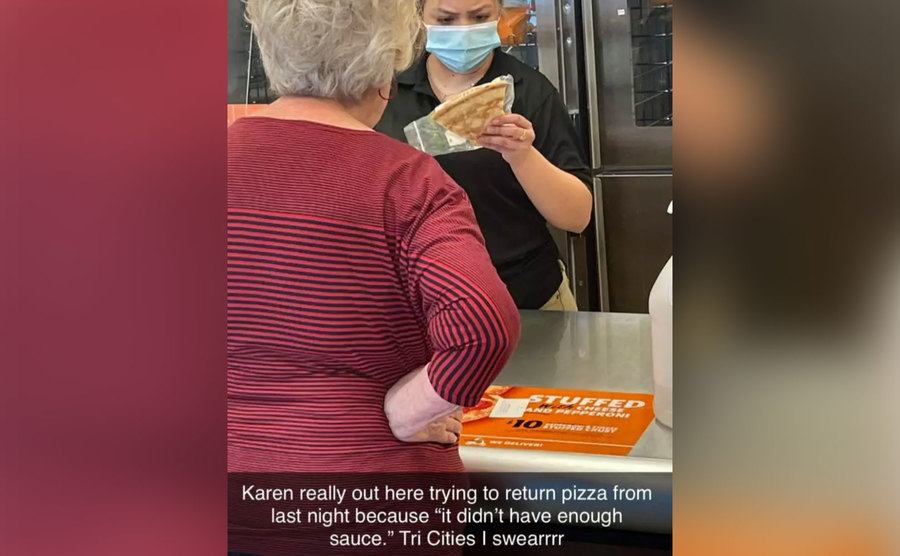 An older woman hands a pizza worker a single pizza slice in a plastic bag. 
