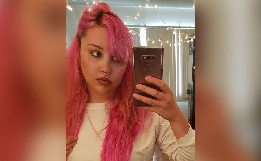 A mirror selfie of Amanda Bynes with hot pink hair. 
