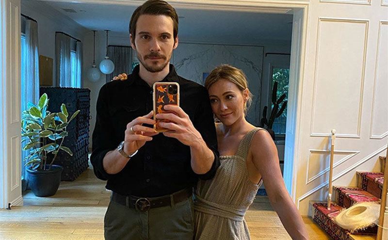 Hilary and her husband take a mirror selfie at home.