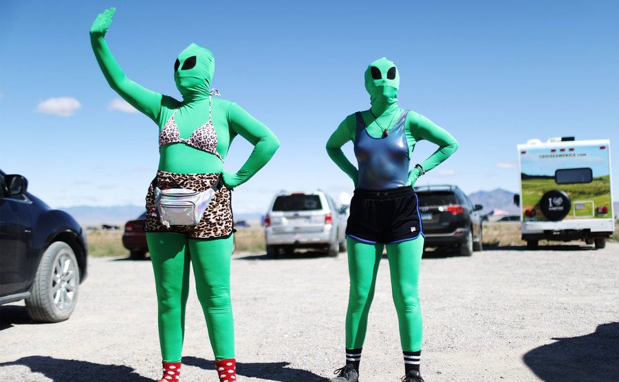 Women are dressed as aliens at a 'Storm Area 51' event. 