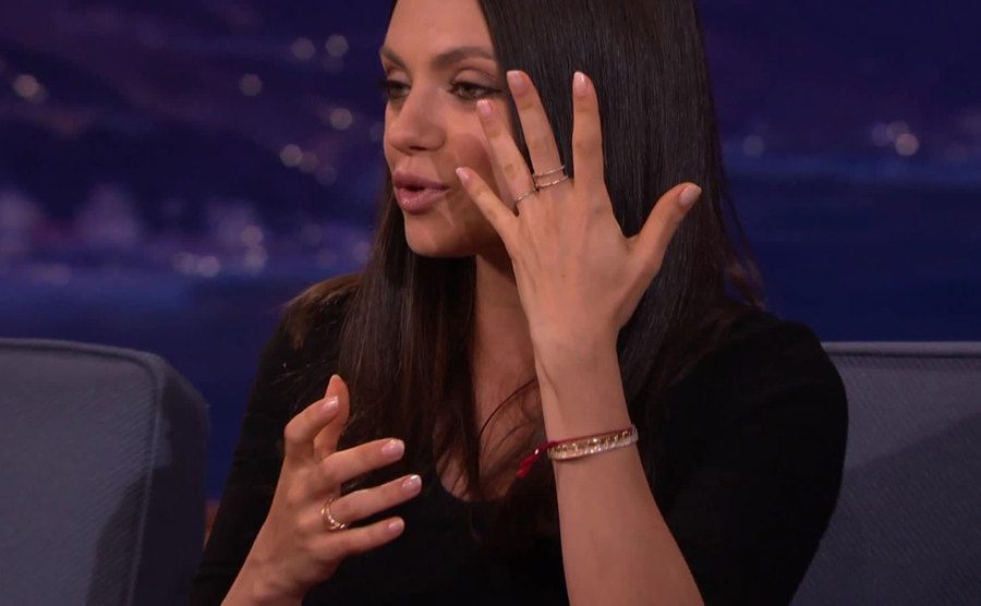 Mila Kunis is showing off her wedding ring on a talk show. 