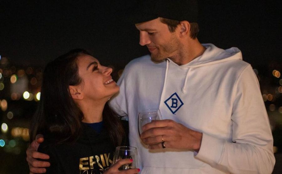 Kunis and Kutcher share a drink on a rooftop. 