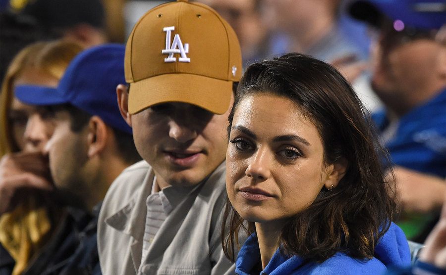 Ashton Kutcher and Mila Kunis attend a baseball game. 