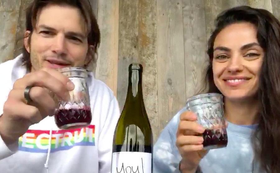 Mila and Ashton raise their glasses of wine for a toast. 