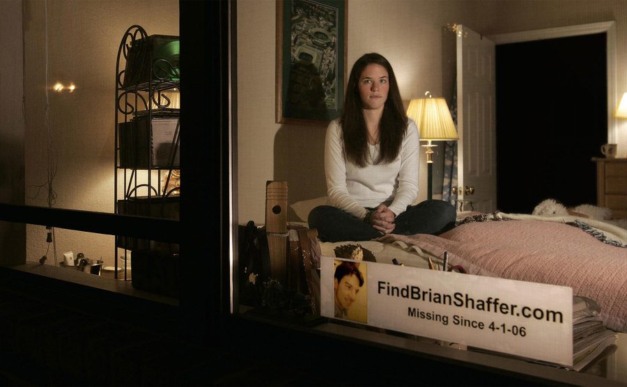 Alexis sits in her campus dorm room with a sign in the window asking to find Brian. 