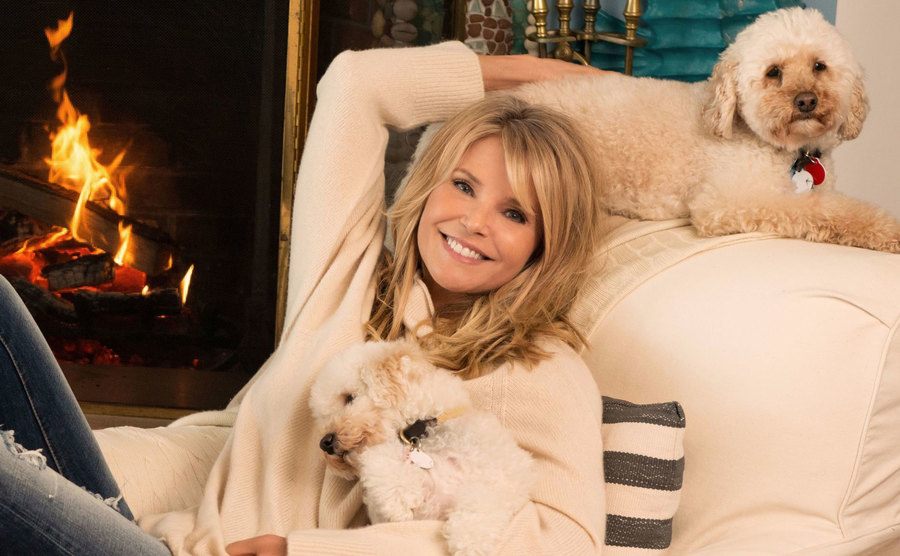 Brinkley sits in a lounge chair with her two dogs. 