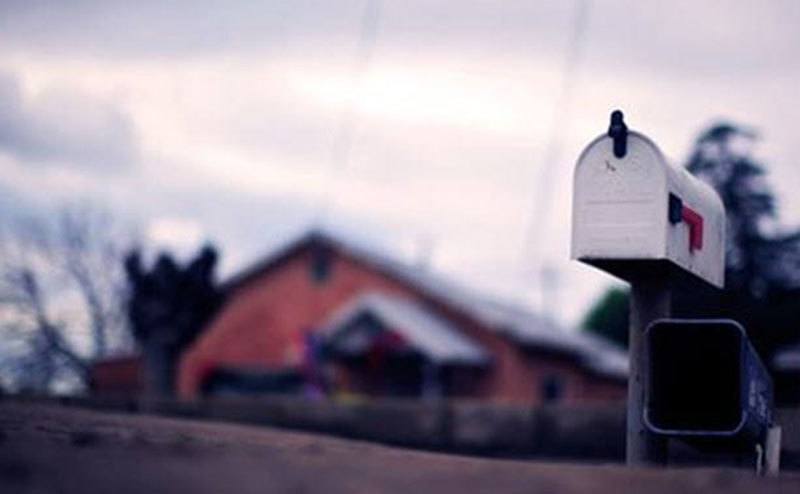A picture of a mailbox next to a house.