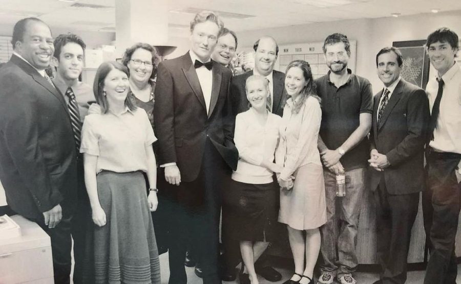 Conan poses on the set of The Office along with the cast. 