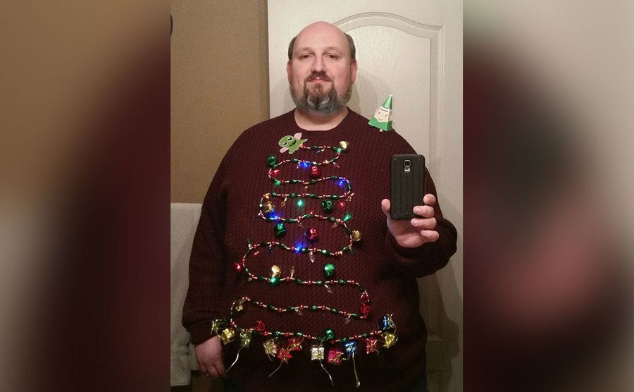 A sweater with a string of lights across shaped like a Christmas tree. 