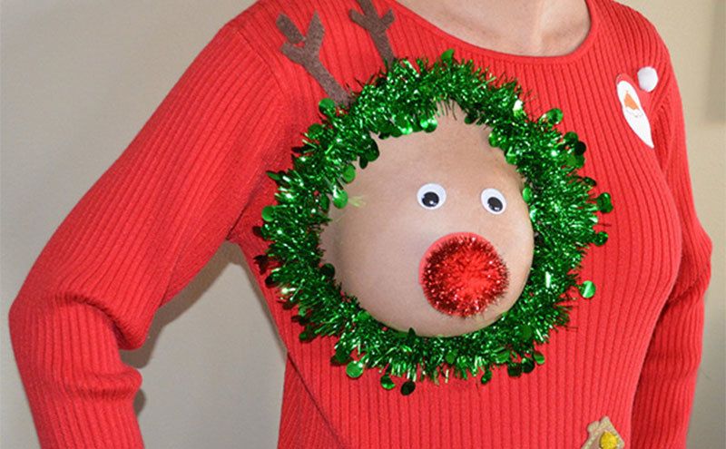 A woman wearing a sweater which a boob cut-out that looks like a reindeer. 
