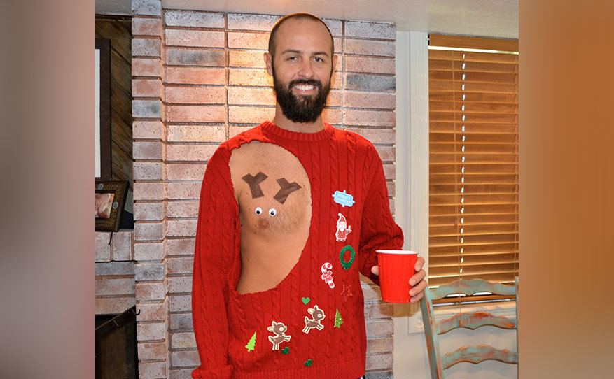 A man is wearing a sweater with the nipple is showing, and it looks like a reindeer. 