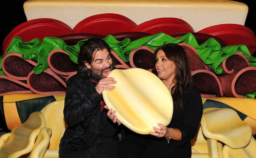 Rachael and her husband pose next to a giant plastic burger.