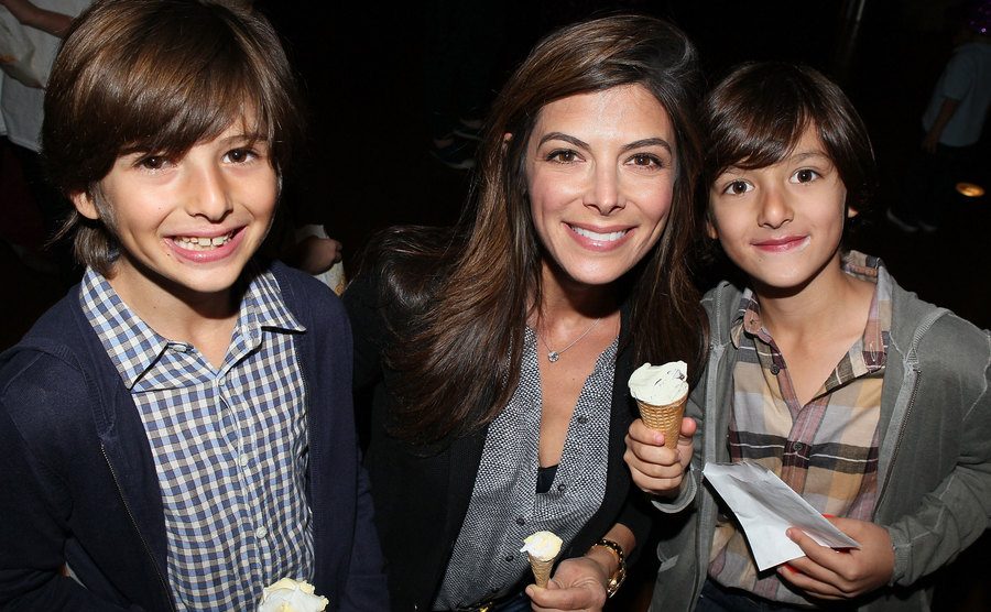 A photo of Alexandra Adi with her children attending an event.