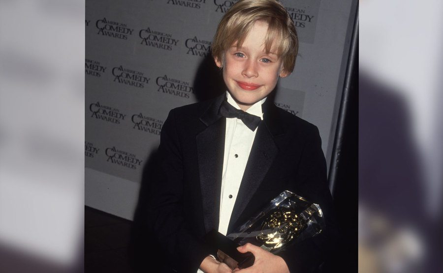 A portrait of Macaulay holding an award.