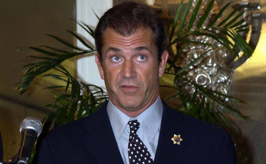 A dated picture of Mel Gibson speaking on stage.