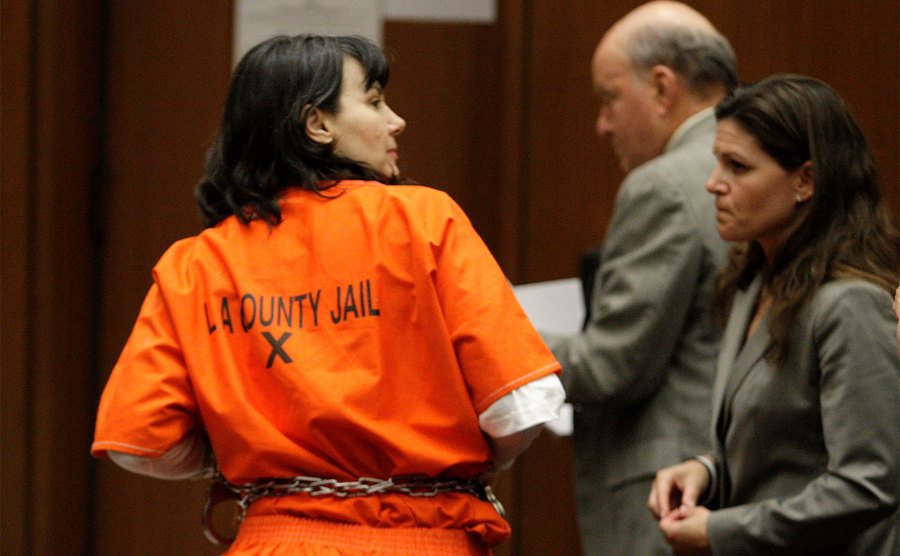 Stephanie Lazarus stands in handcuffs in court. 