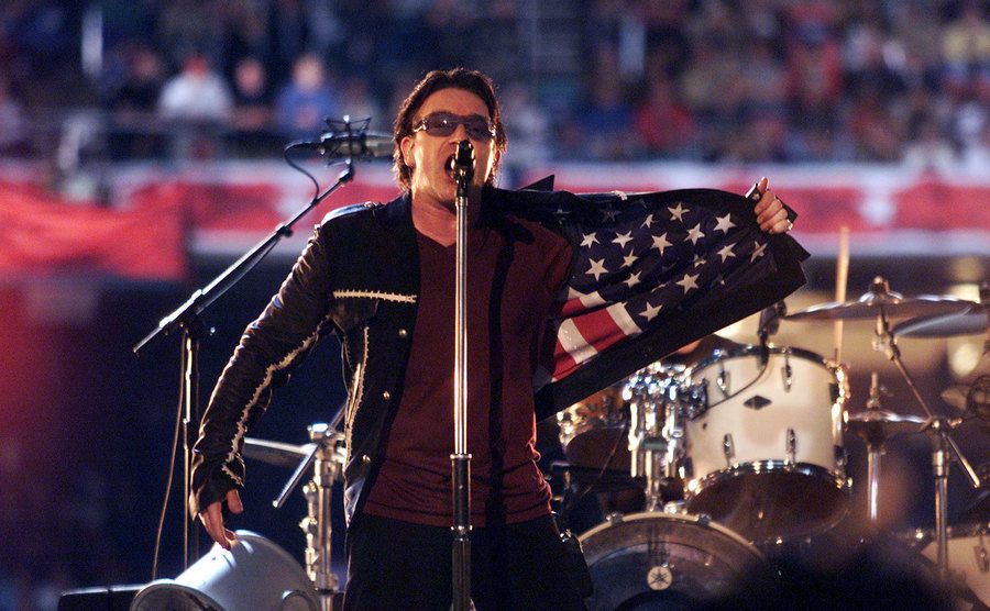 Bono flashes an American flag on the inside of his jacket during the Super Bowl XXXVI. 