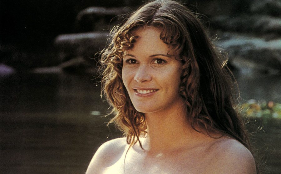 Elle is seen swimming in the lake in a still from Sirens. 