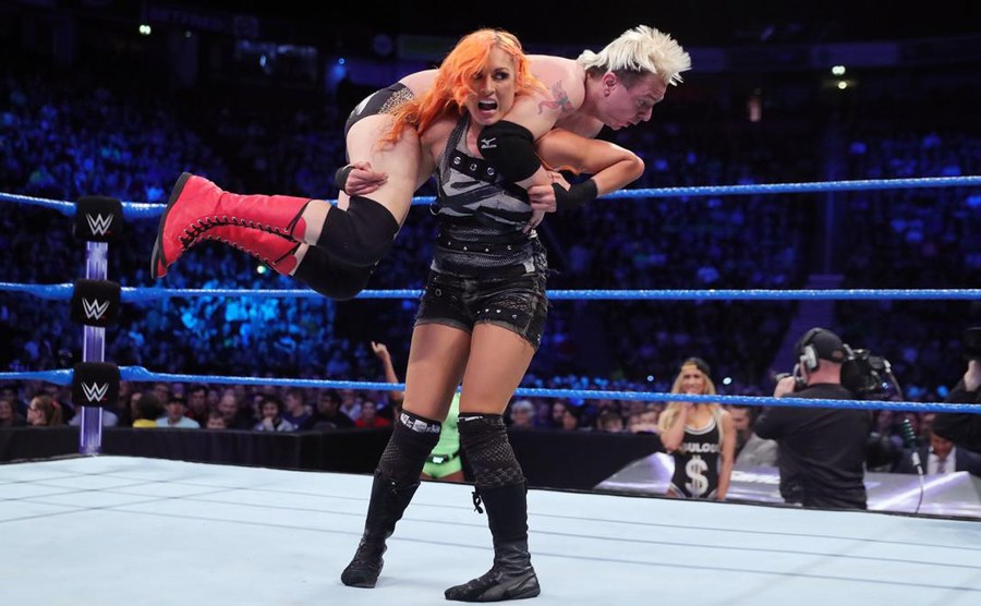 Becky Lynch lifts James Ellsworth on her shoulders in the ring. 