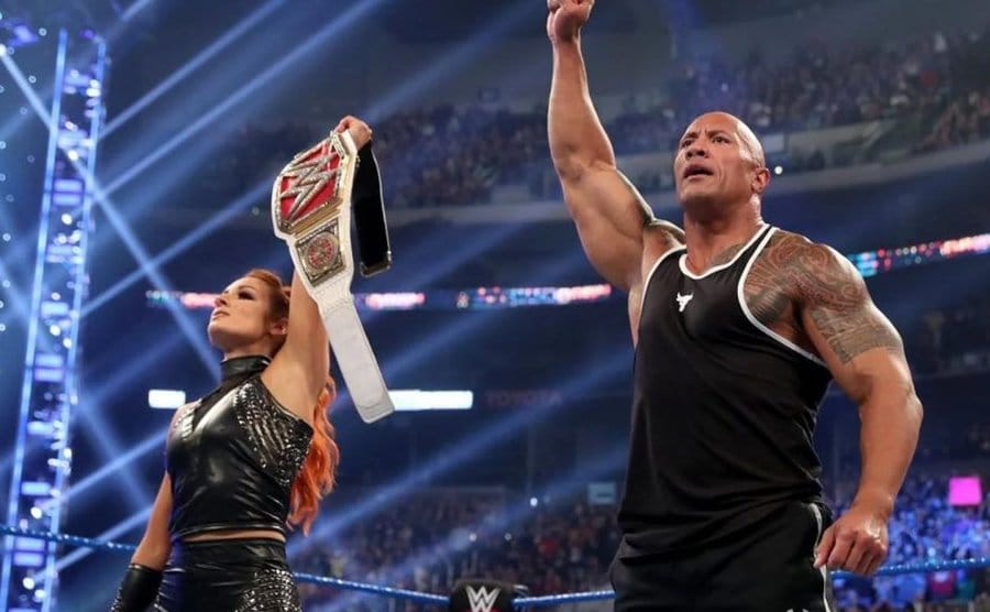 Becky is in the ring with Dwane “The Rock” Johnson. 