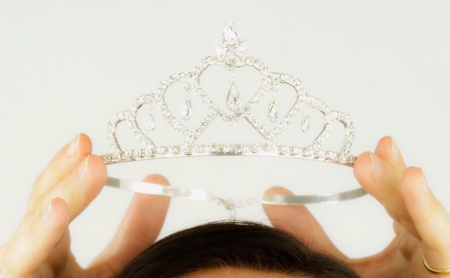 An image of a woman having a tiara placed on her head.
