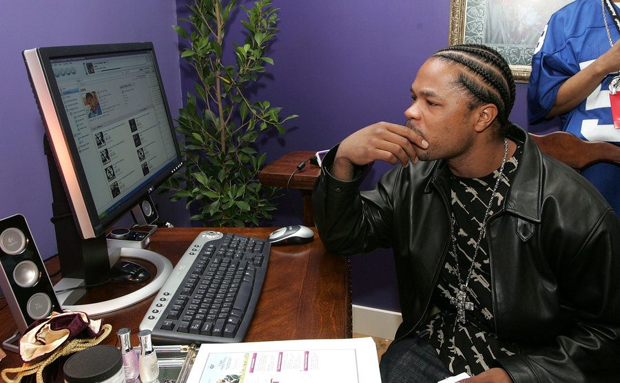 A photo of Xzibit sitting in front of a computer.