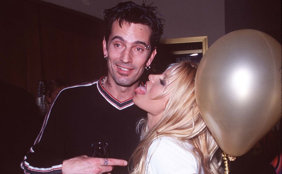 Tommy Lee and Pamela Anderson are backstage at a concert. 