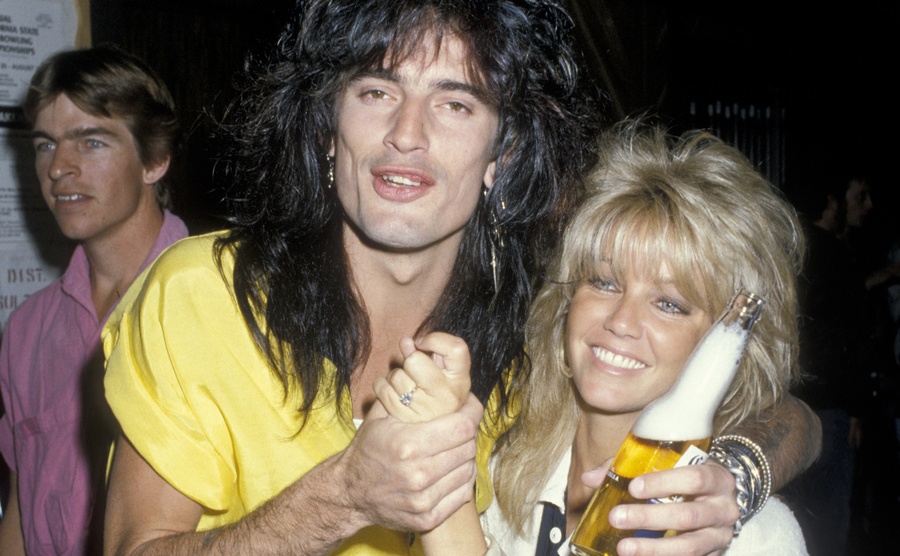 Tommy Lee and Heather Locklear pose for a photo at a party. 