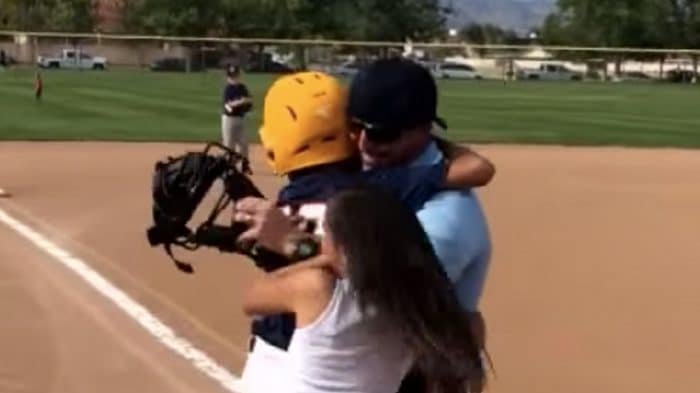 young baseball player hugging his family