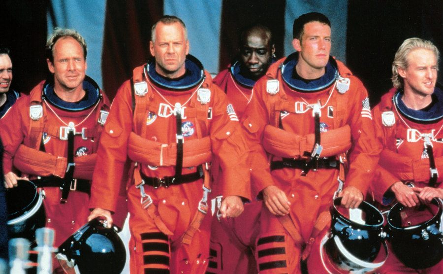 Steve Buscemi, Will Patton, Bruce Willis, Michael Clarke Duncan, Ben Affleck, and Owen Wilson are walking in NASA uniforms in a scene from the film.