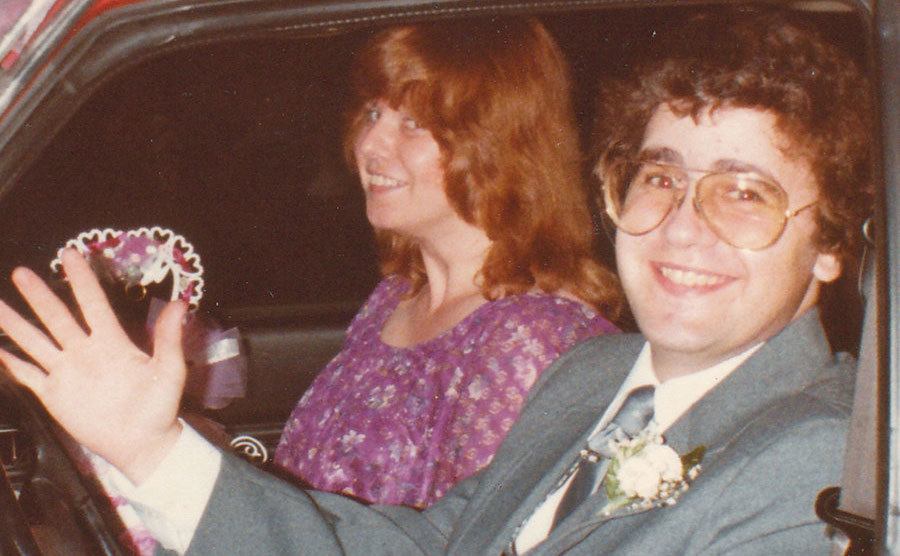 A photo of Linda and John inside a car after their wedding.