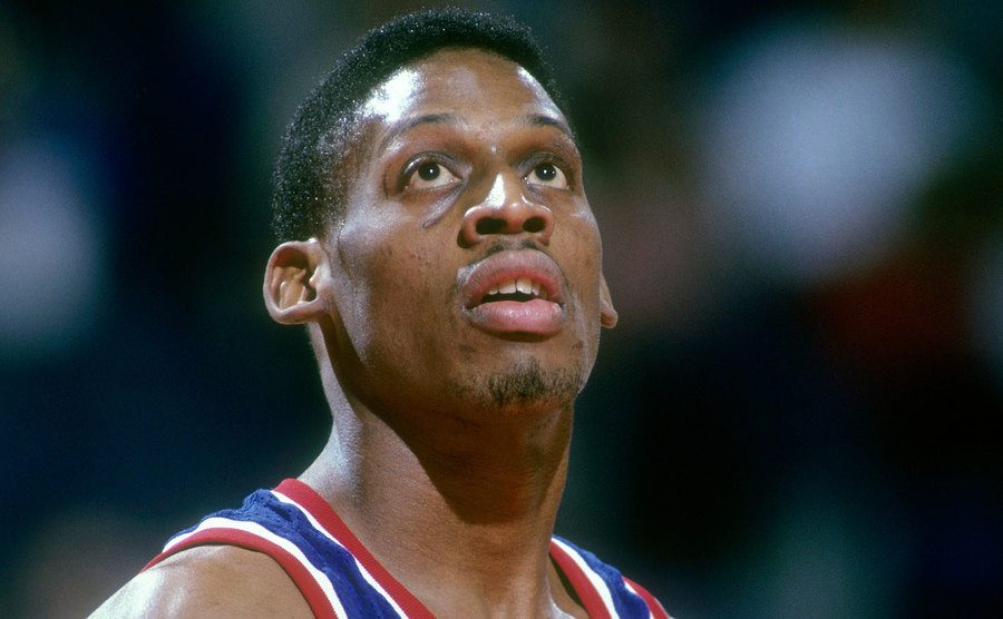 A picture of Rodman looking up at the basket during a basketball game.