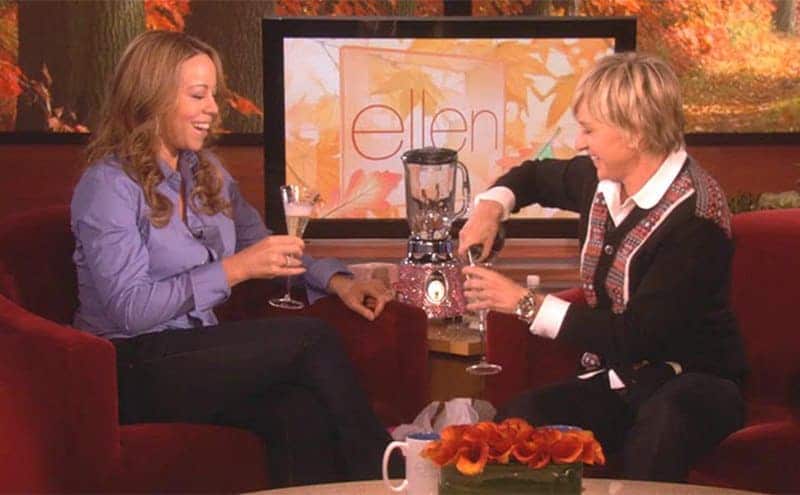 Mariah Carey holding a glass of champagne on the Ellen DeGeneres show 
