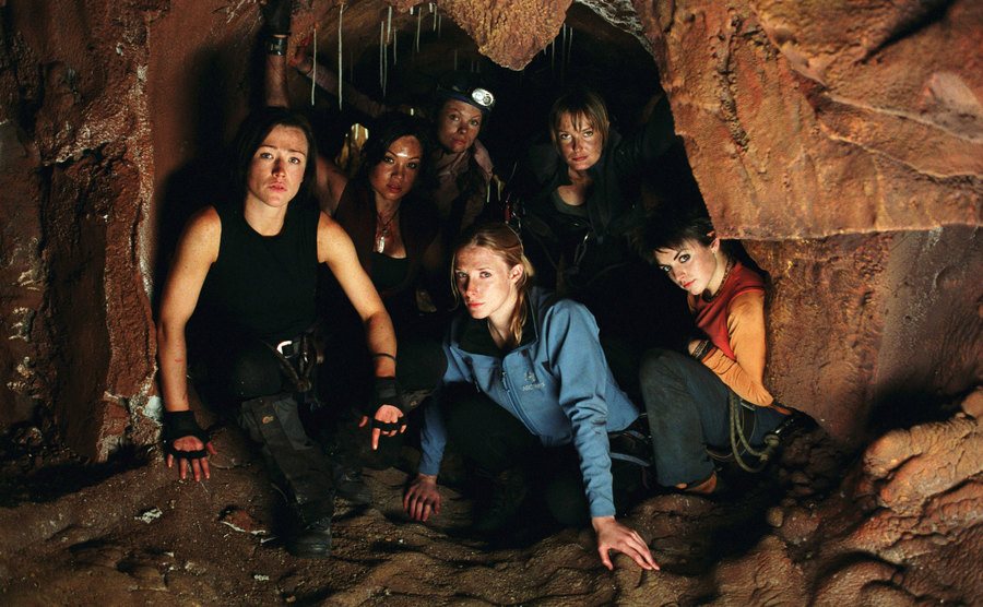 The cast of The Descent is crouching in the cave. 
