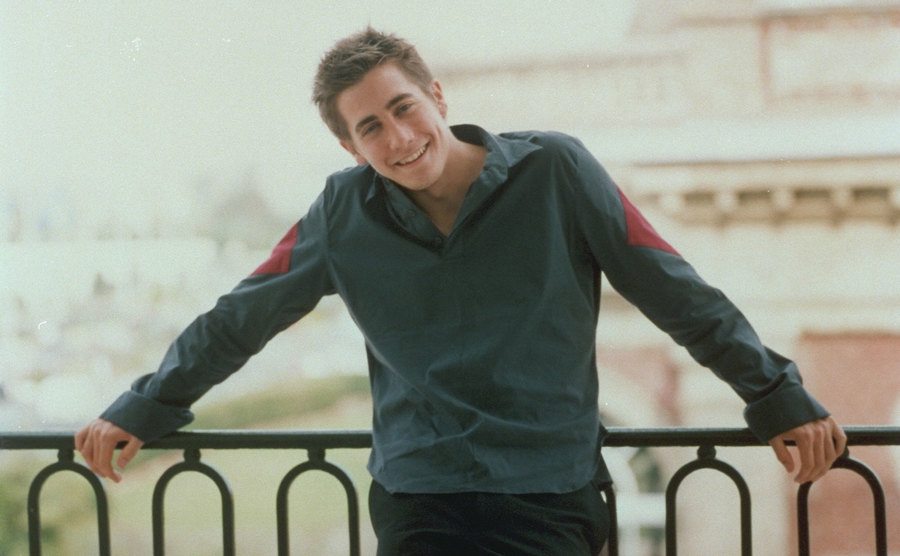 Jake Gyllenhaal poses on a porch. 