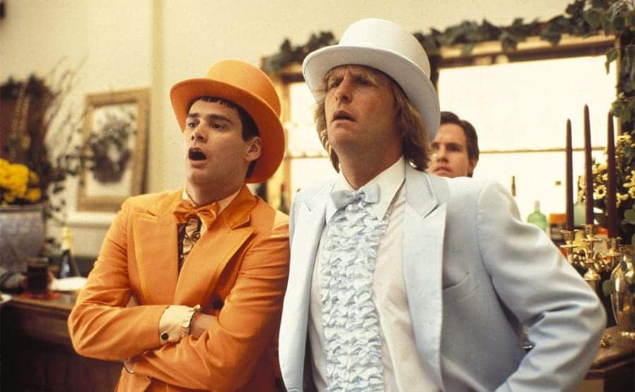 Jim Carrey and Jeff Daniels in orange and blue old prom suits with matching top hats in Dumb and Dumber 1994