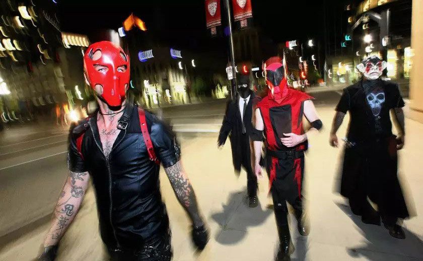 Masked vigilantes walk down the streets. 