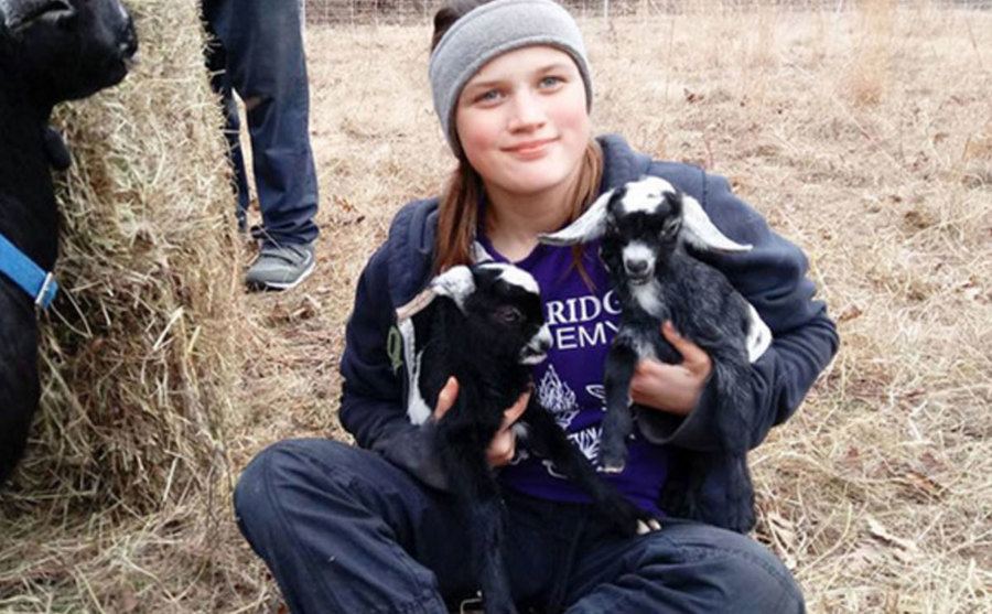An image of Savannah playing with the baby goats on the farm.