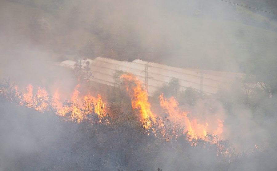 An aerial view of a farm bursting in flames.