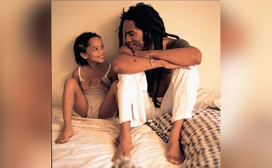 Lenny and Zoe Kravitz are sitting together on the bed in an old photo. 