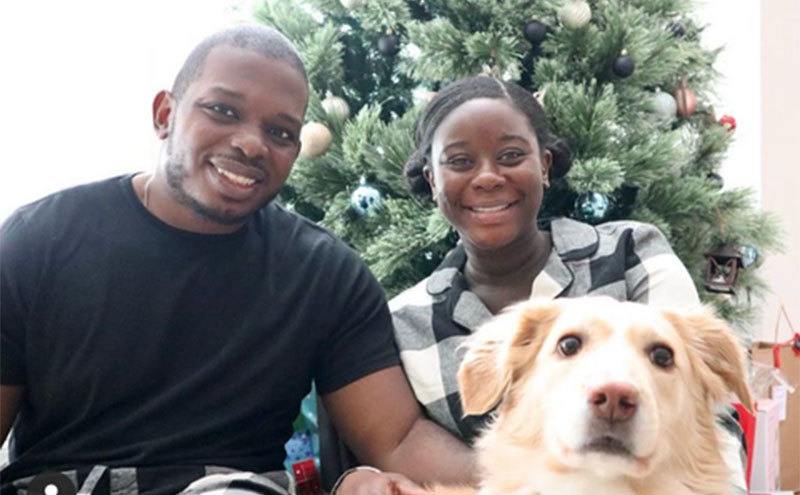 Deonna McNeill and Gregory Okotie take a photo with their dog. 