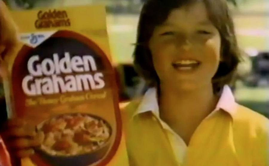 Jason Bateman holds up a box of Golden Grahams.
