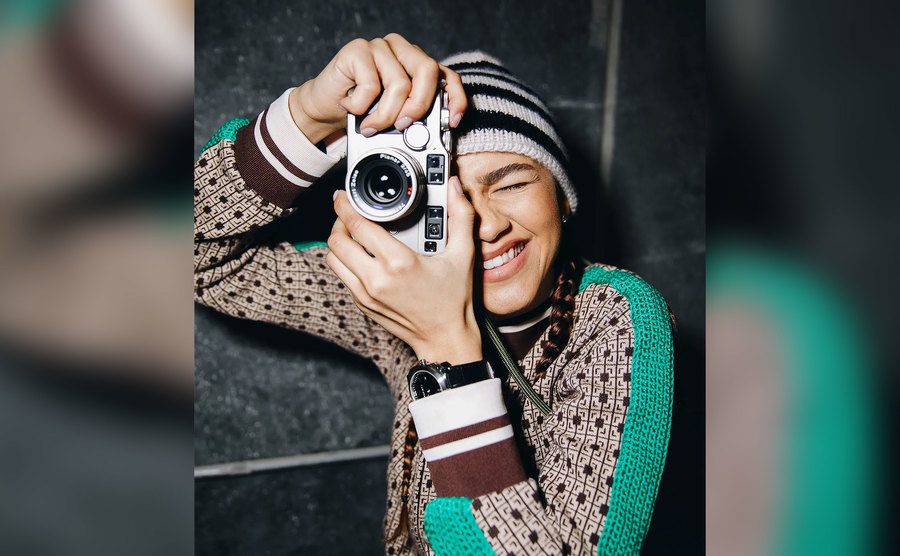 Zendaya takes a picture with her camera. 