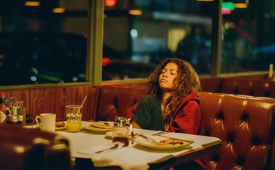 Zendaya sits in a diner in a still from Euphoria. 