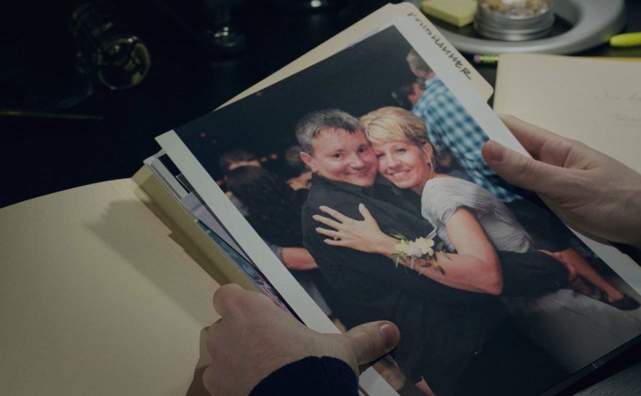 A photograph of Todd and Barbara is held in a video still.