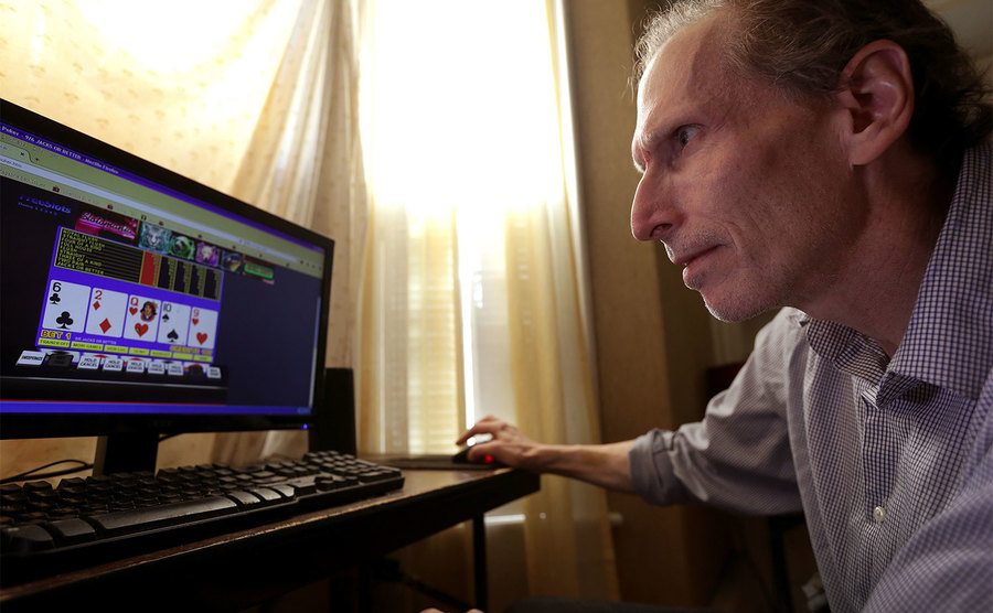 A man plays online poker in his home. 