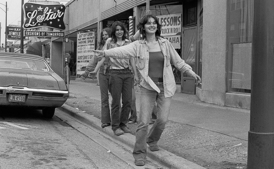 A photo of a group of young girls hitchhiking.