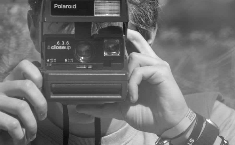 An image of a man taking a polaroid picture.