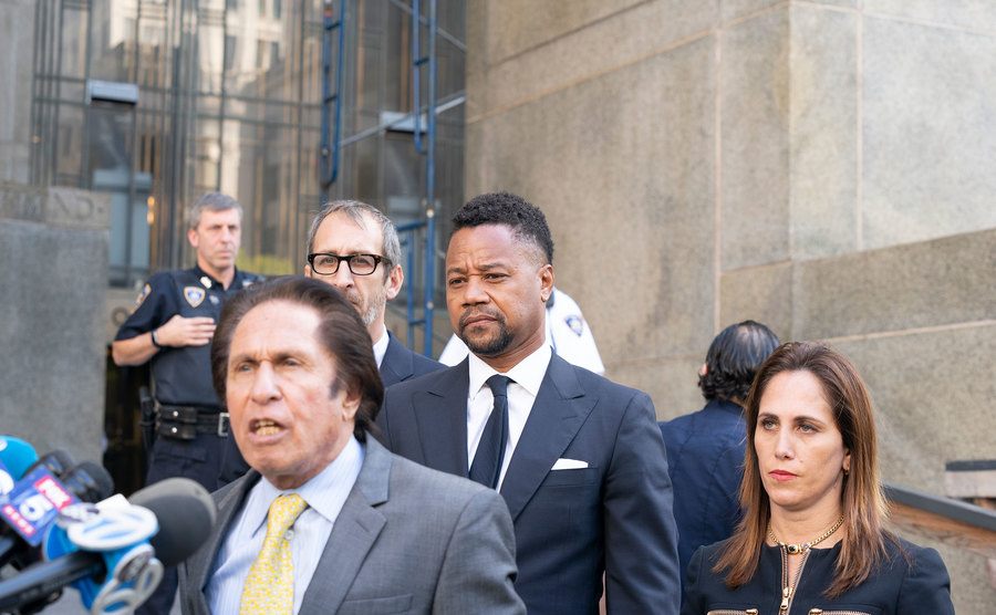 A picture of Gooding Jr. leaving court with his lawyers.